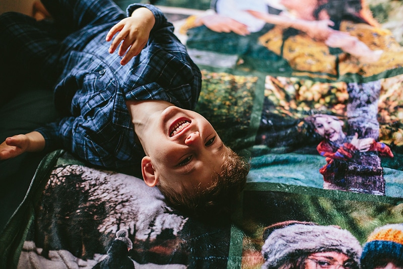 Kid lying down on a customised Photo Blanket