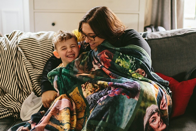 Mom and child on a sofa covering with a customised Photo Blanket