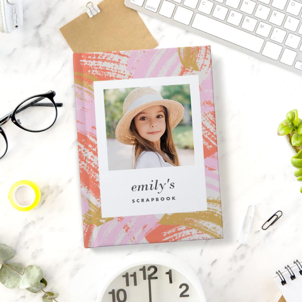 A pink personalised notebook with an image of a little girl presented on an office desk