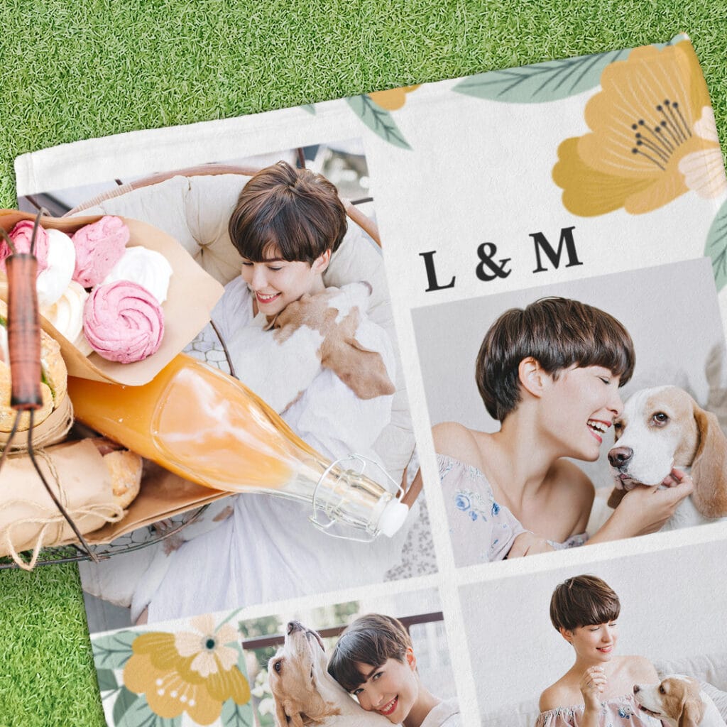 A picnic blanket with images of a girl and a dog placed on a meadow below a picnic basket