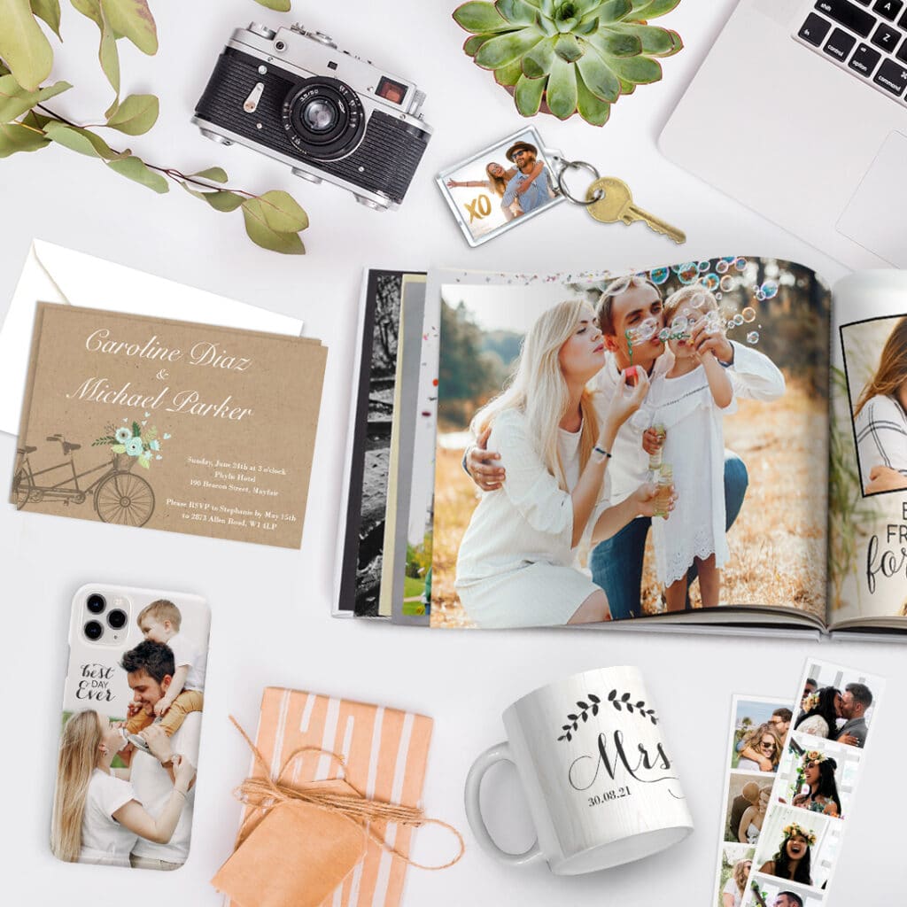 A collage of products offered by Snapfish, an open photo book, card, key ring, mug, phone case and strip prints presented on a surface with a camera and a gift box.