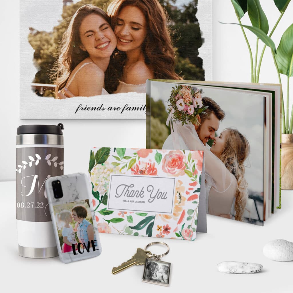 A set of photo gifts offered by Snapfish, a lovely canvas, photo book, key chain, travel mug, phone case and a card placed on a desk.