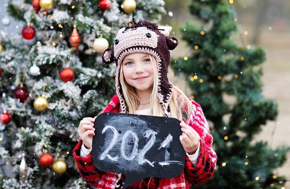 a lovely young girl holding a 2021 year sign in her hands