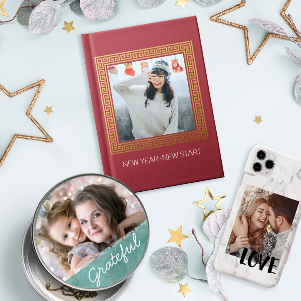 a personalised round tin, a diary and a phone case on a surface with golden stars and leaves