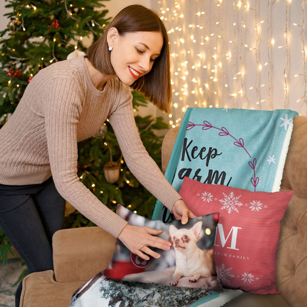 lovely smiling woman putting custom cushions and a blanket on the sofa