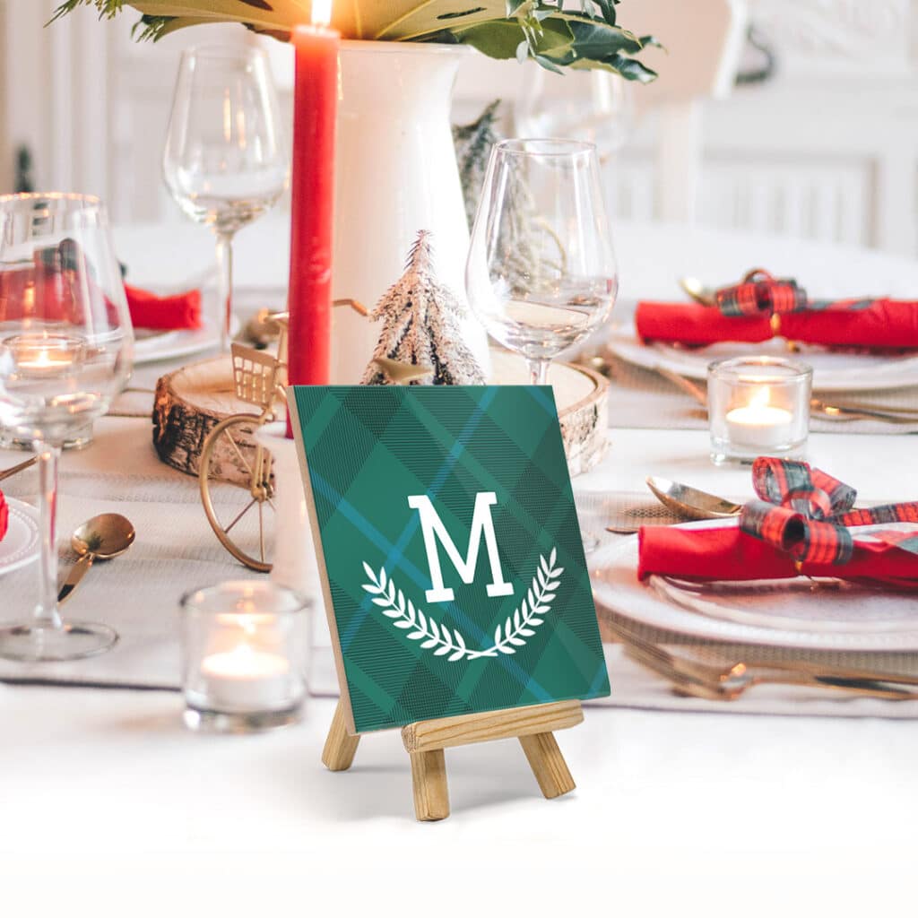 A personalised ceramic tile with stand placed on a table as a name tag 