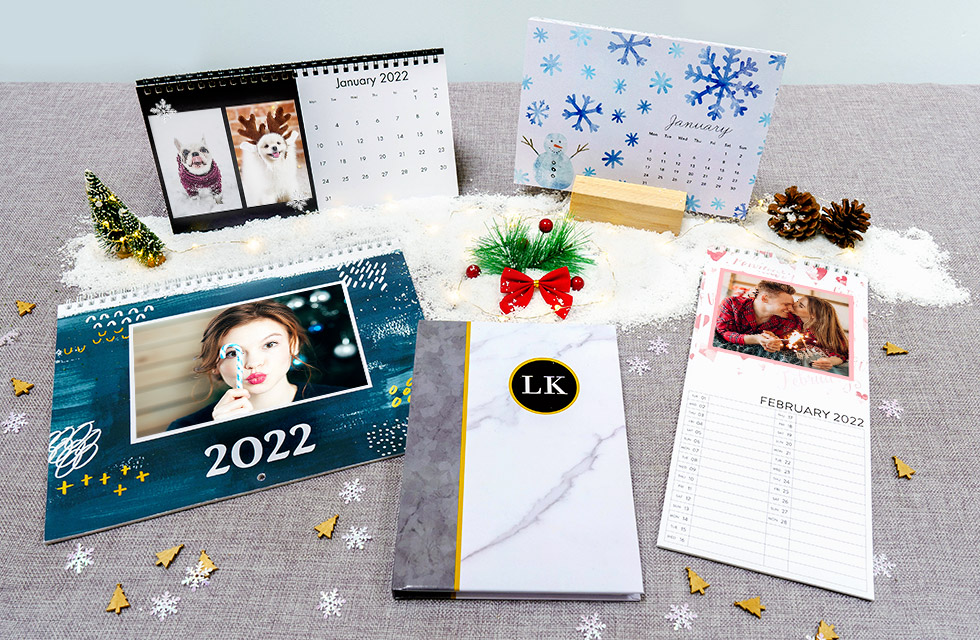 A selection of personalised calendars dispayed on a surface with Christmas decoration