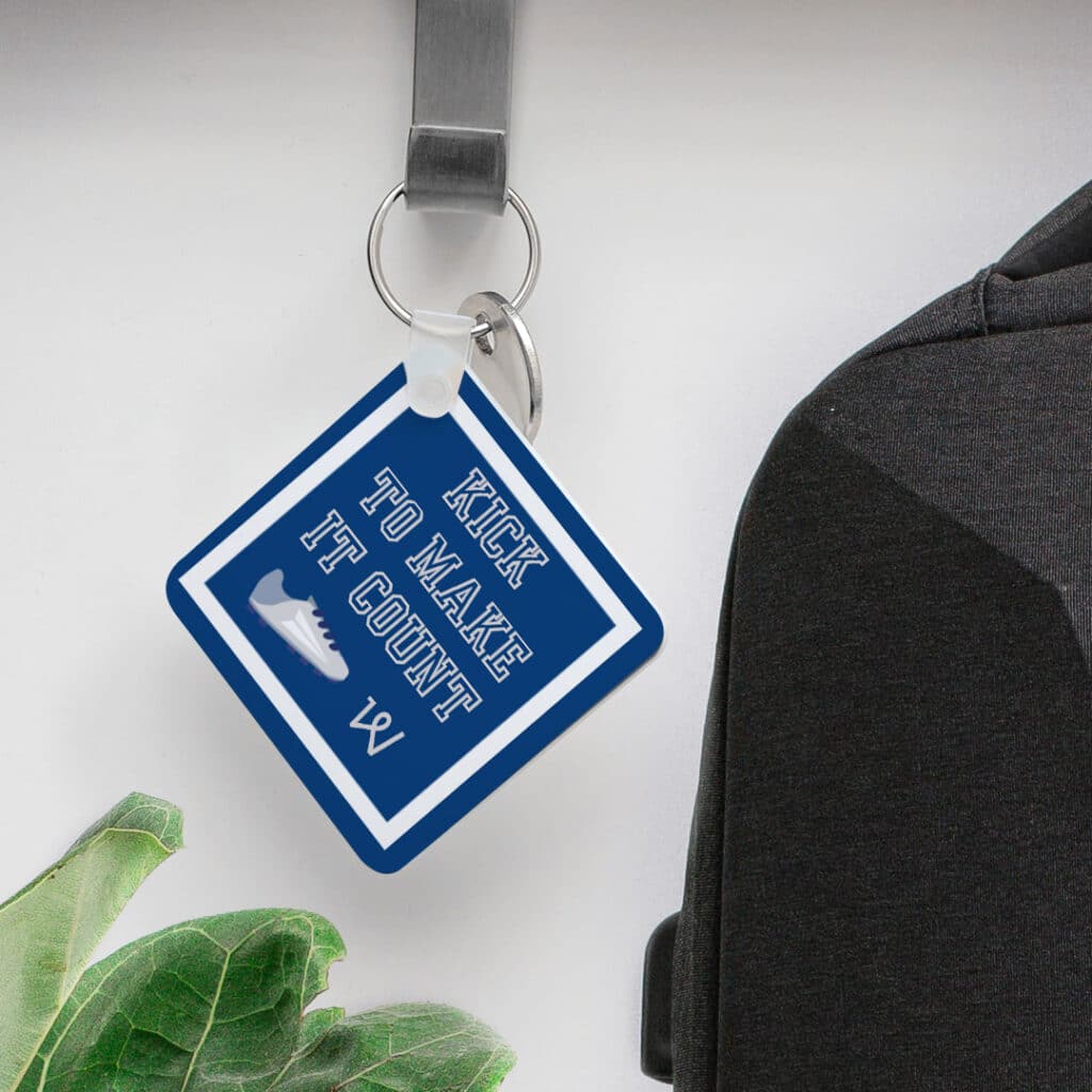 a square slimline keyring with 'kick to make it count' slogan printed on it
