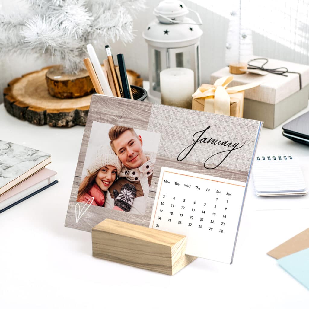 a wood block calendar with the month of January and a photo of a lovely young couple