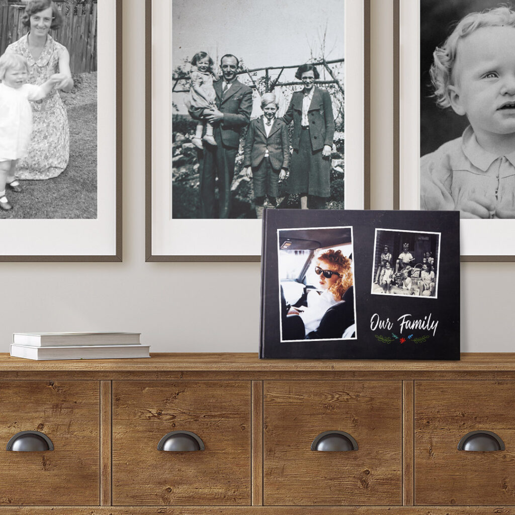 family history photo book in front of old framed photos