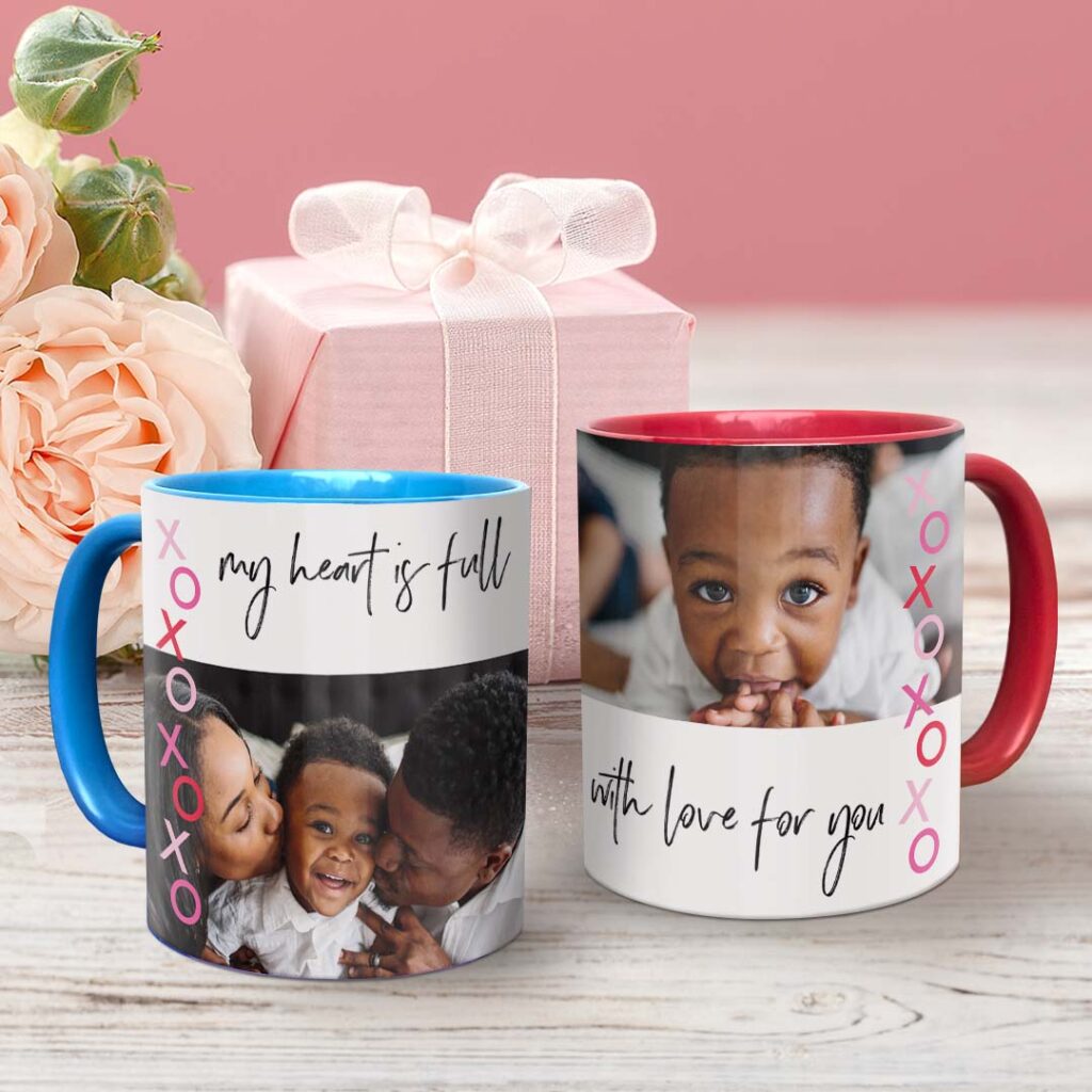 two colored mugs in front of present and roses with Love themed designs