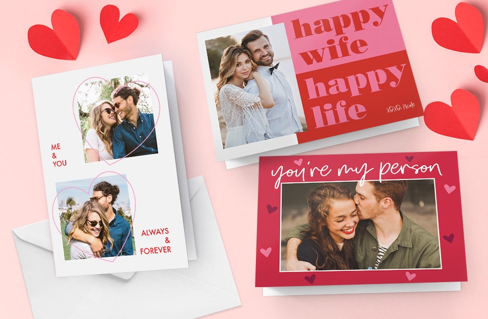 A selection of new custom Valentine's day cards presented on a pink surface with red paper hearts