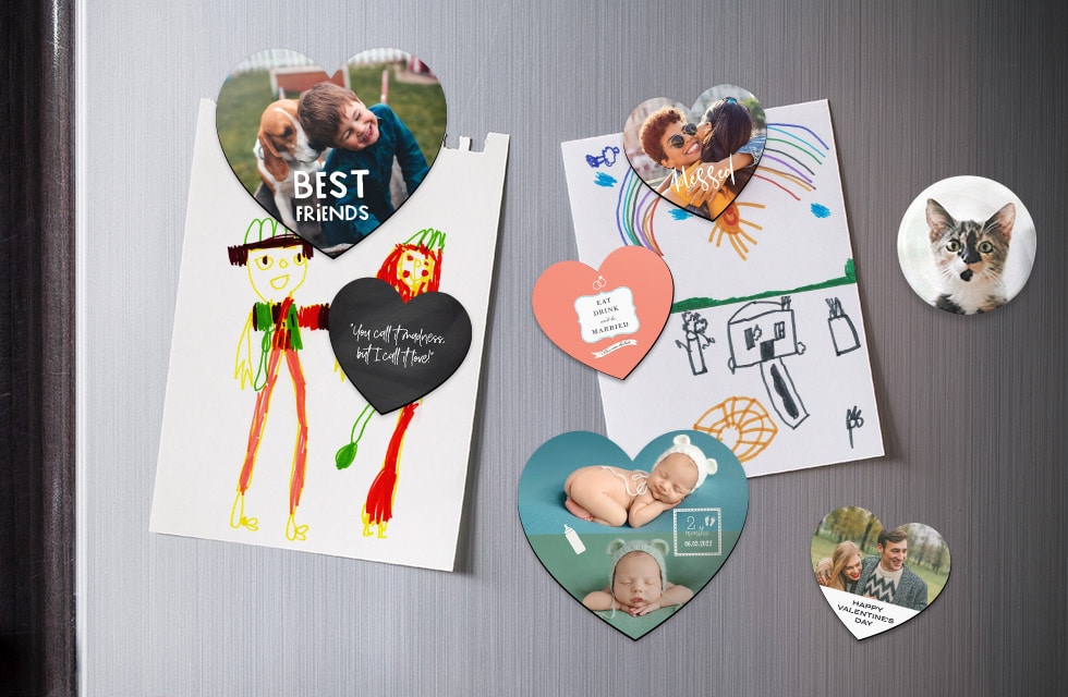 A selection of heart magnets holding children's drawings on a fridge