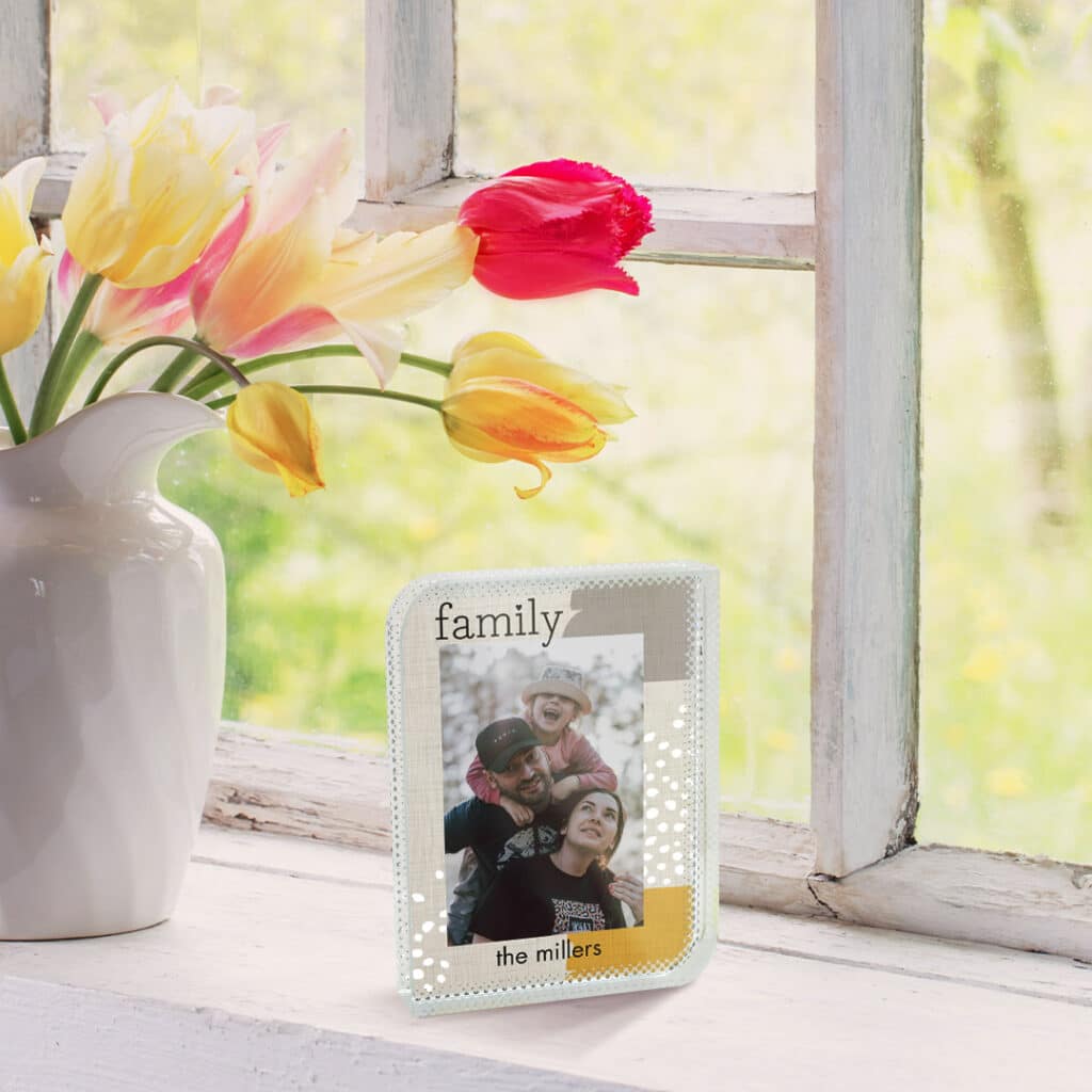 glass photo block next to a ceramic pot with tulips