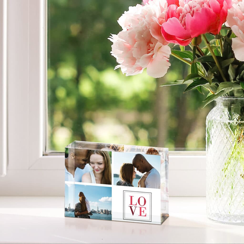 acrylic photo block next to a glass bottle with flowers