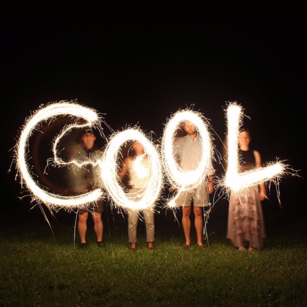 Family with sparklers spelling out Cool
