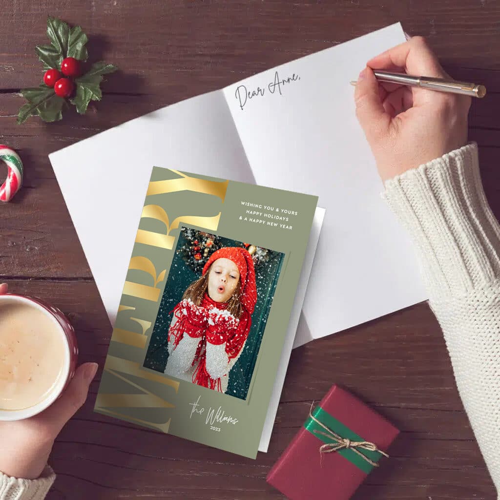 A person writing inside of a Christmas card